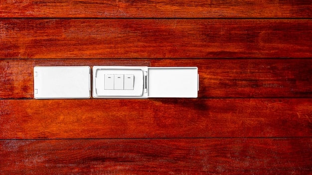 A close-up of a standard light switch being removed from a wall, with various smart dimmer switches and tools laid out on a nearby table, ready for installation.