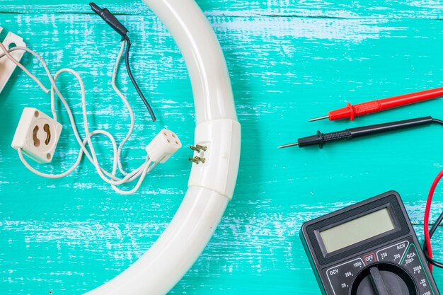 A close-up of various tools needed for smart thermostat installation, including screwdrivers, wire strippers, a voltage tester, and wire connectors, all laid out neatly on a workbench.
