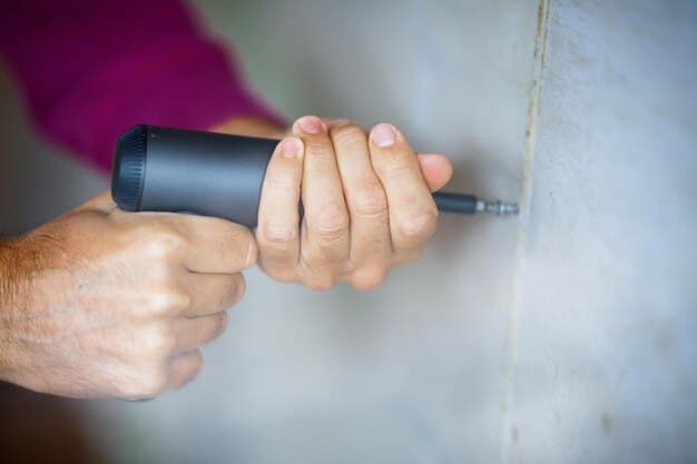 A close-up of hands using a screwdriver to tighten screws on a smart lock during the installation process. The door is partially visible in the background.