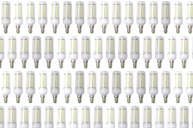 A close-up of a variety of LED bulb shapes and sizes, including A19, BR30, and candelabra bulbs, each with clear labeling of wattage and lumen output.