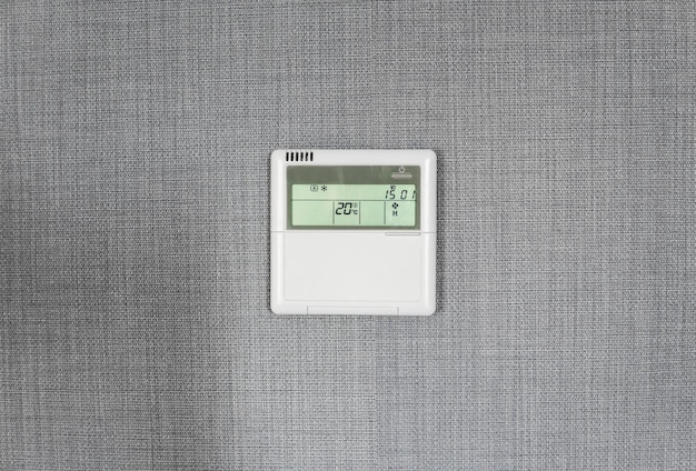 A smart thermostat is displayed on a wall, showing a graph of temperature changes throughout the day. A person is adjusting the temperature using the thermostat's touch screen. The surrounding room is well-lit and modern.